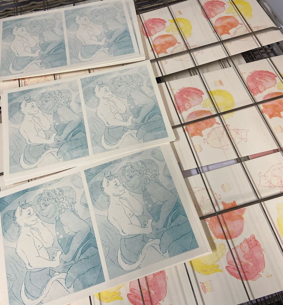 Two partially finished riso prints designs in rows on a drying rack.