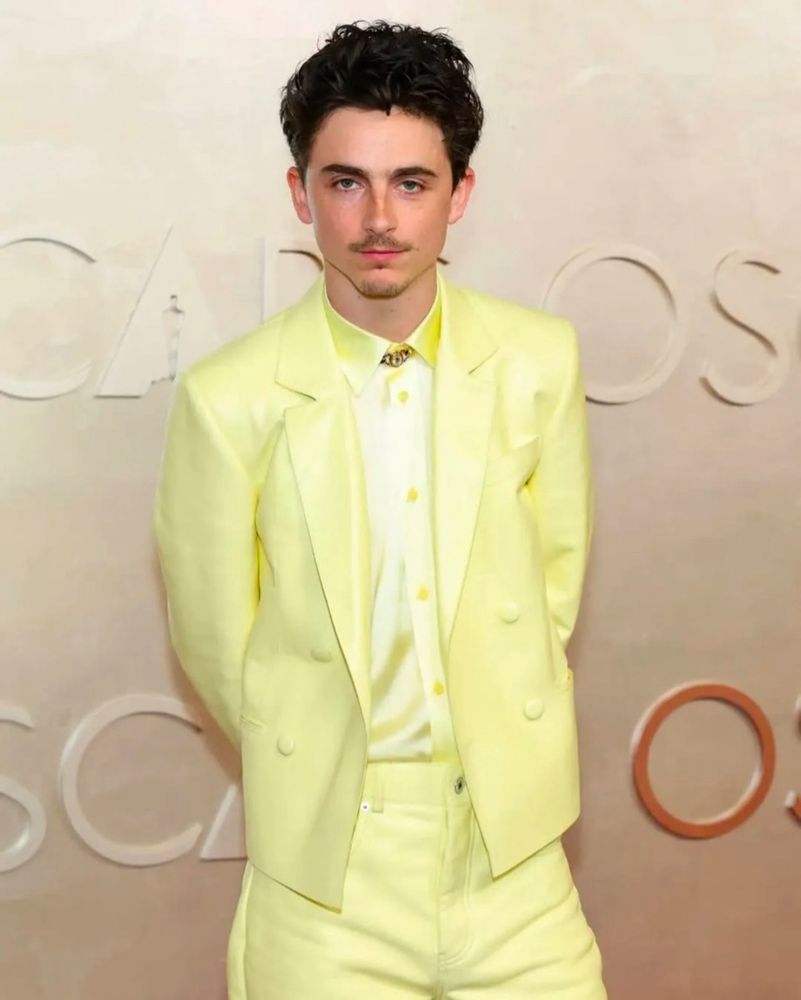 A man in a light yellow suit facing forward