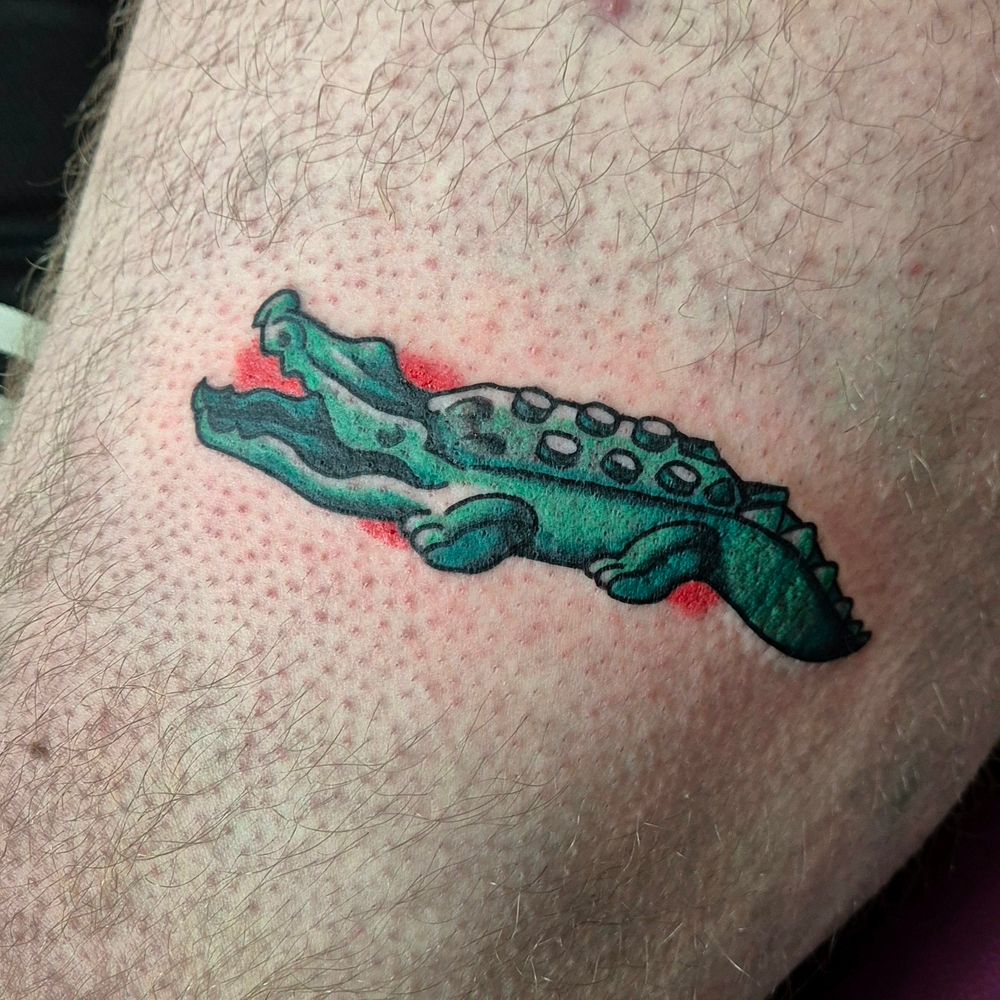 A colorful tattoo of the original LEGO crocodile from the 90s.