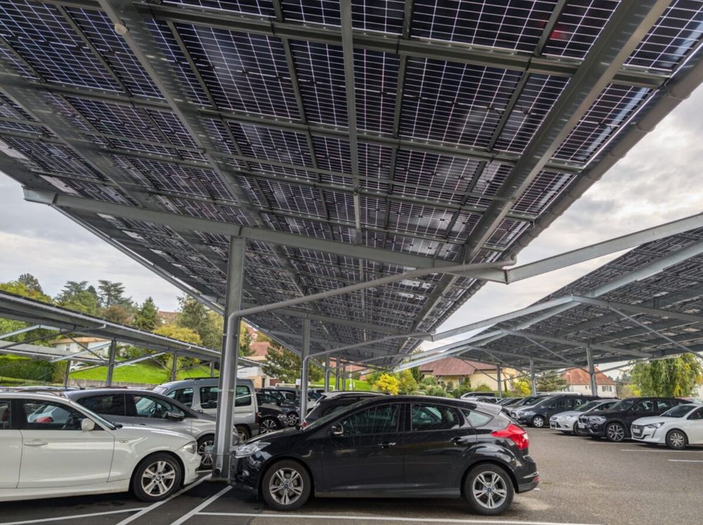 Foto eines Parkplatzes, der mit Solar-Panelen überdacht ist.