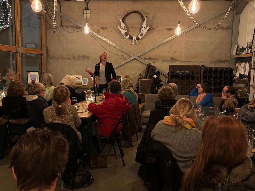 A room of people listening to a speaker 