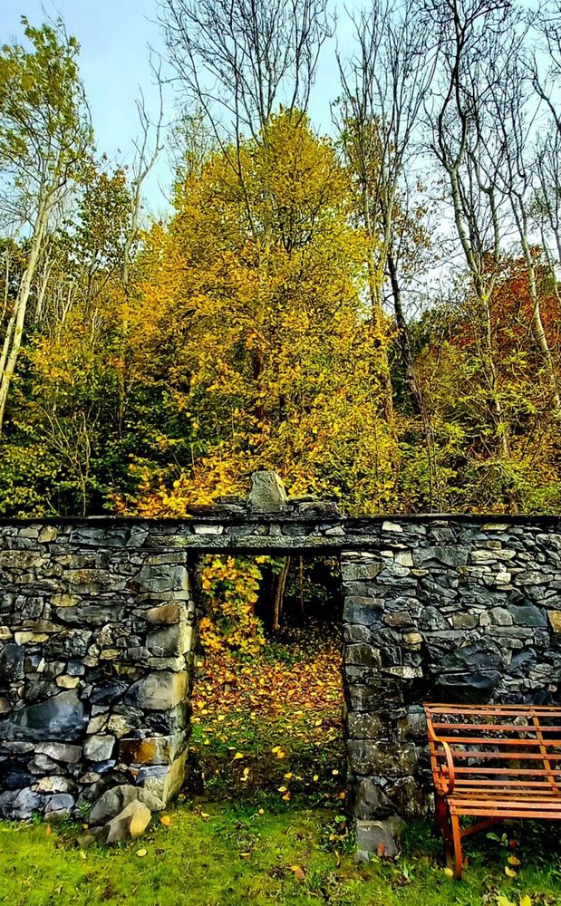 A stone gateway with trees beyond 