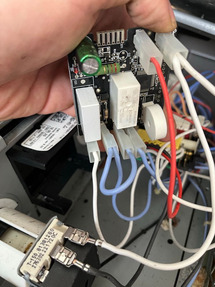 Elektronische Steuerplatine mit Relais, Kondensator und mehreren Kabelverbindungen.