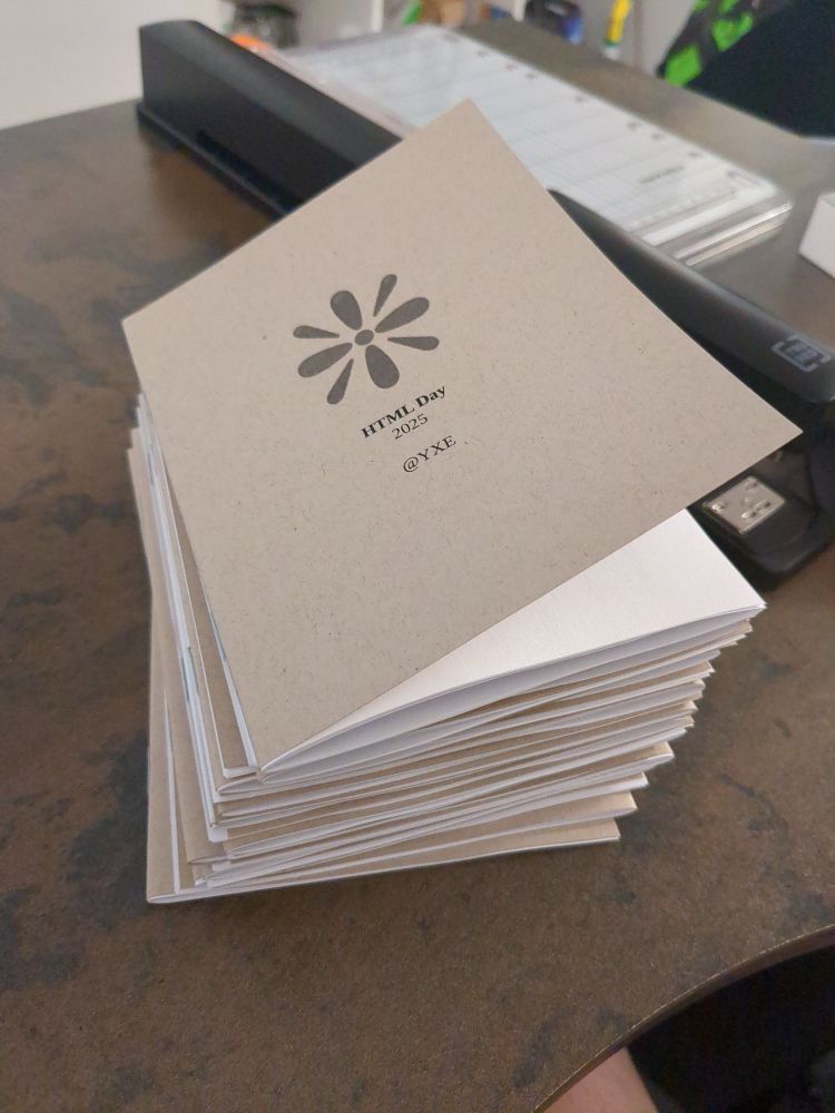 A pile of small brochures titled "HTML Day 2025 @YXE"
