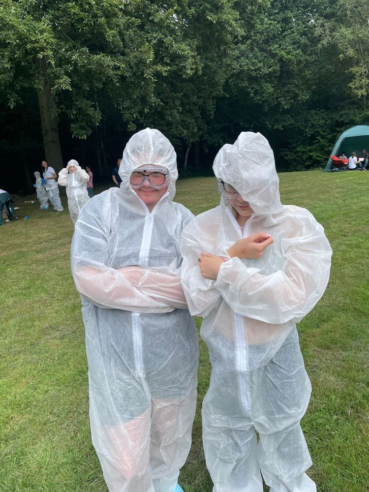 Two white teenage girls in clear boiler suits get ready for painting at Teenvine's summer camp out 2024.
