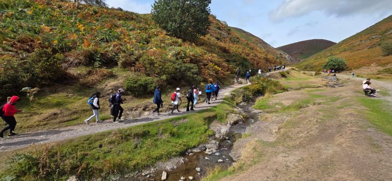 Following a path along a stream, the group begins the climb.
