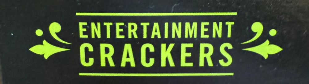 A cropped picture of a black box with lime green lettering and filigree that says “Entertainment Crackers” 