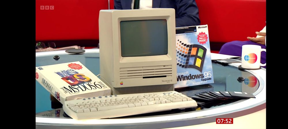 Some Windows 95 and MSDOS software boxes around a Macintosh SE computer