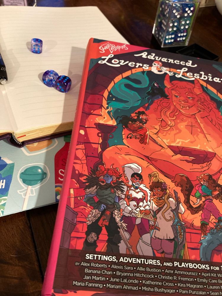 Dice and a book for the game Thirsty Sword Lesbians.
