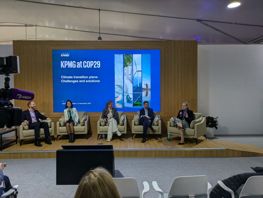 A panel at COP29 talking about transition plans. Mardi McBrien of IFRS Foundation holds the microphone.