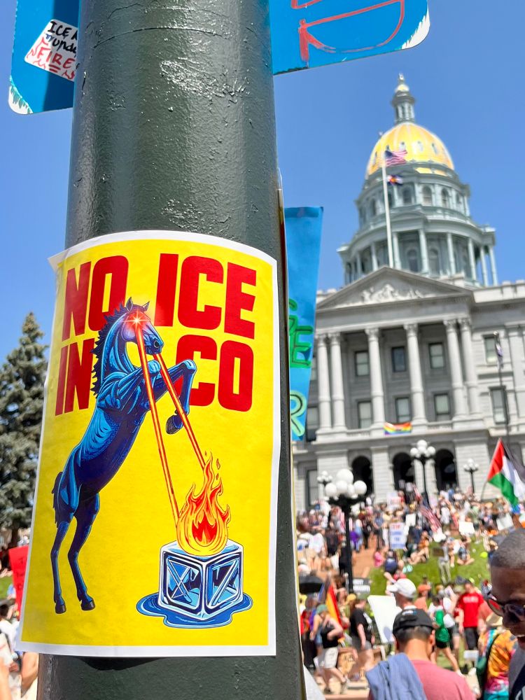 It’s a picture of a poster taped to a light post in front of the Denver state capitol, with text reading NO ICE IN CO. Blucifer the demon mustang is shooting fire at an ice cube with the lasers from his demonic red eyes. If you live in Colorado this makes perfect sense.