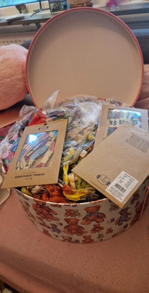 An assorted collection of embroidery floss in a big round box.