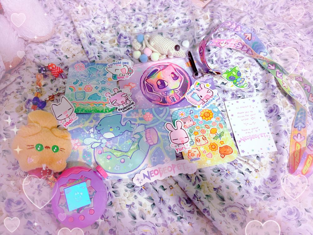 Various things from neogeopet’s shop. A ddr lanyard, 2 sticker sheets, and a bunch of other stickers. A crochet new animal and a tamagotchi make a guest appearance 