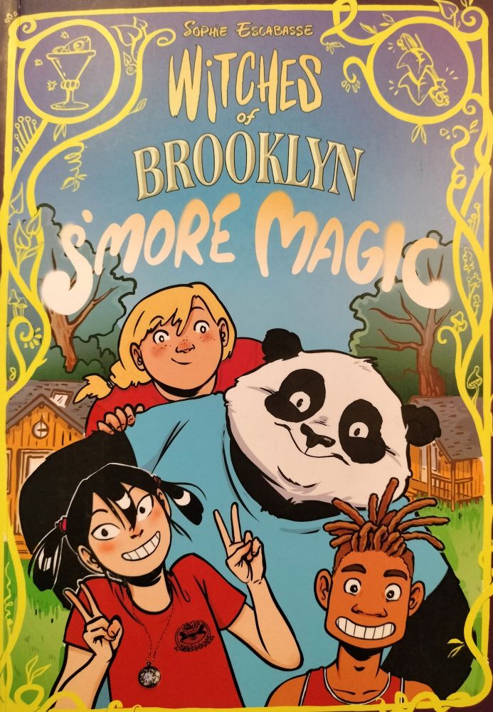 Book cover, blue background with gold curvy lines around the border. Title: WITCHES OF BROOKLYN S'MORE MAGIC. A panda in a blue shirt, framed by a blond, white girl in a red shirt, a white girl with black hair wearing a red shirt, and a Brown boy with brown hair.