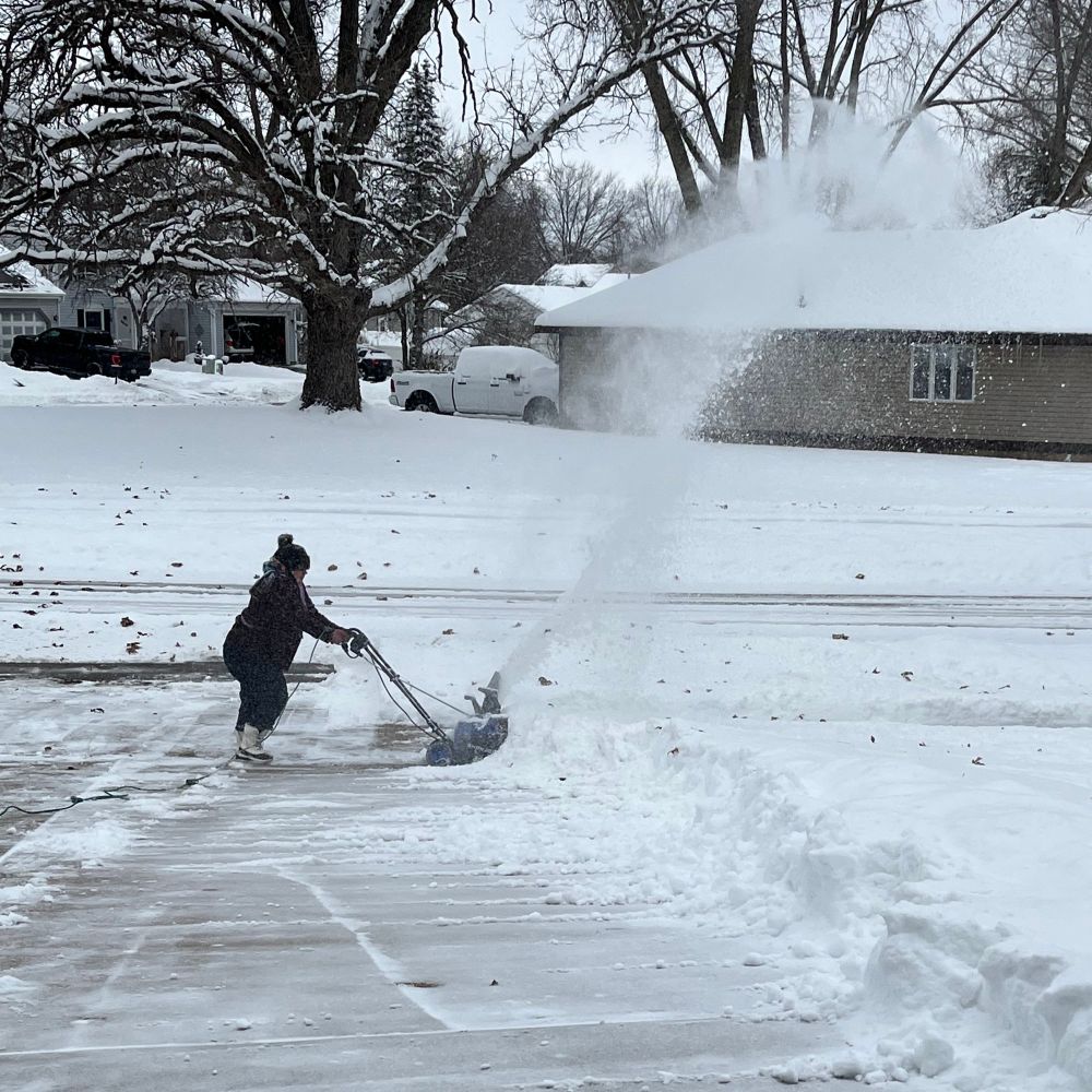 Dr. Wifeprov operating the snow blower and blasting a 15ft tall rope of snow into the neighbor’s lawn