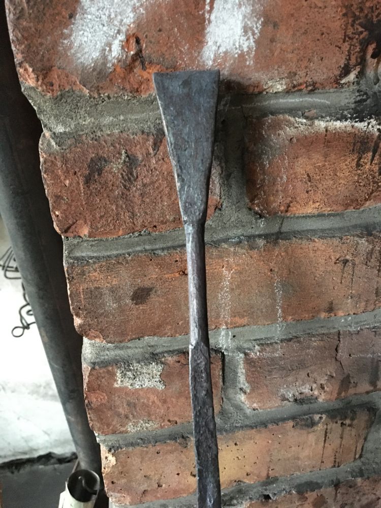 A blacksmith forged belt hook in progress. Currently a welded loop transitioning to a forged rounded section on the end of some flat bar stock