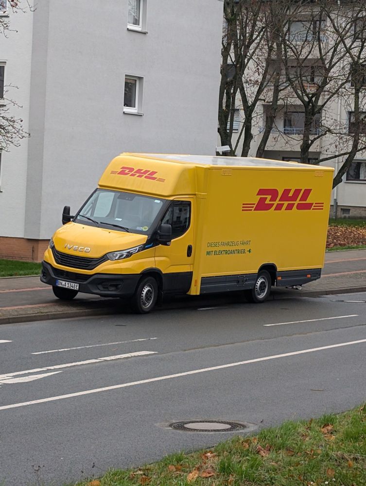 DHL-Lieferfahrzeug mit E-Kennzeichen auf dem Radweg geparkt.