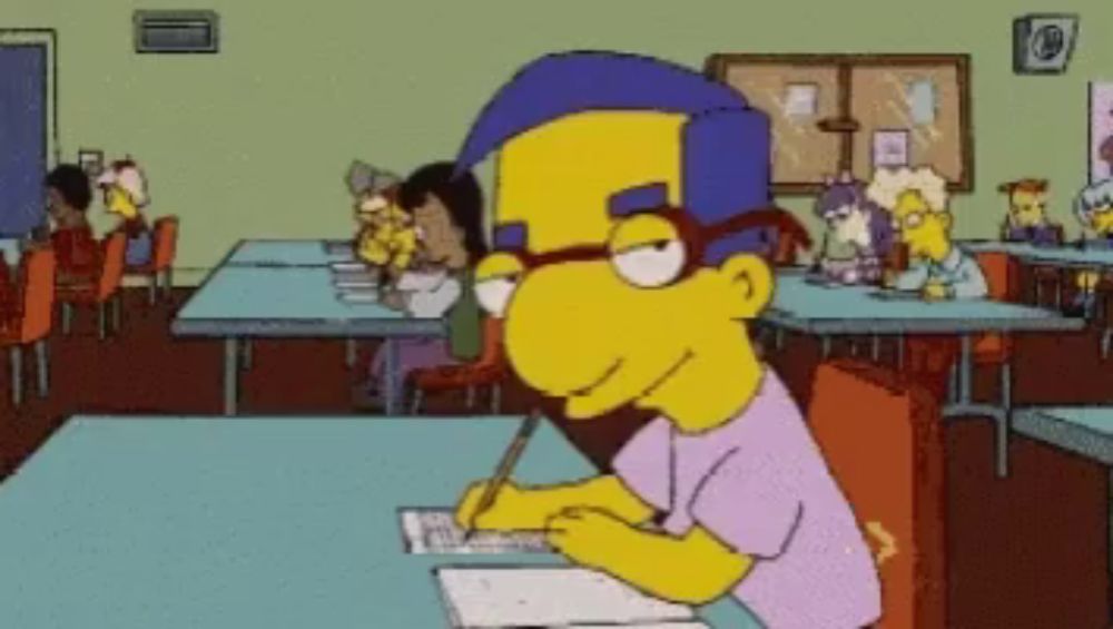 a cartoon character is sitting at a table with a pen in his hand