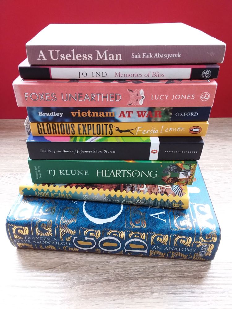 A stack of 9 books of various kinds and sizes. 