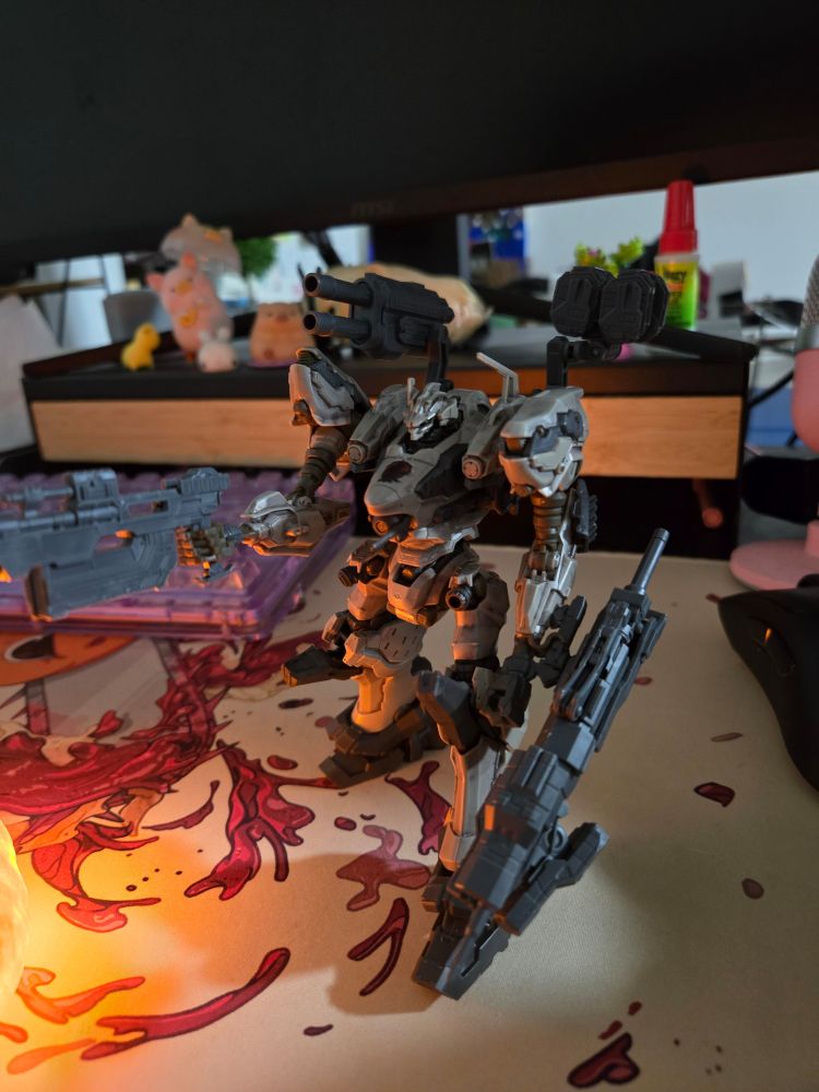 A small plastic model robot is depicted from the videogame series "armored core". Generally armored core robots look more "military and functional" than gundam robots.