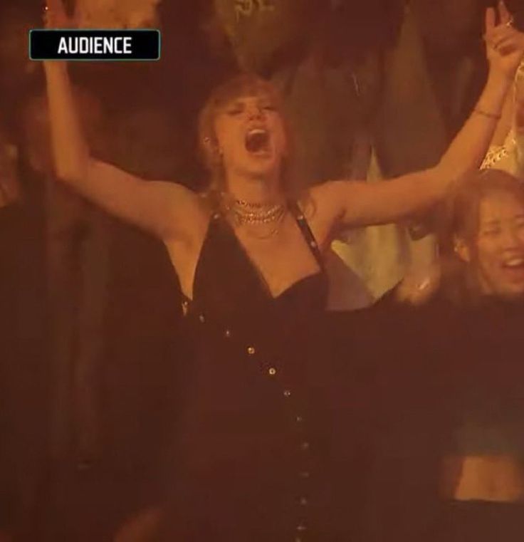 taylor Swift from the VMAs - black dress with her hair up, her hands in the air and her mouth open in a scream