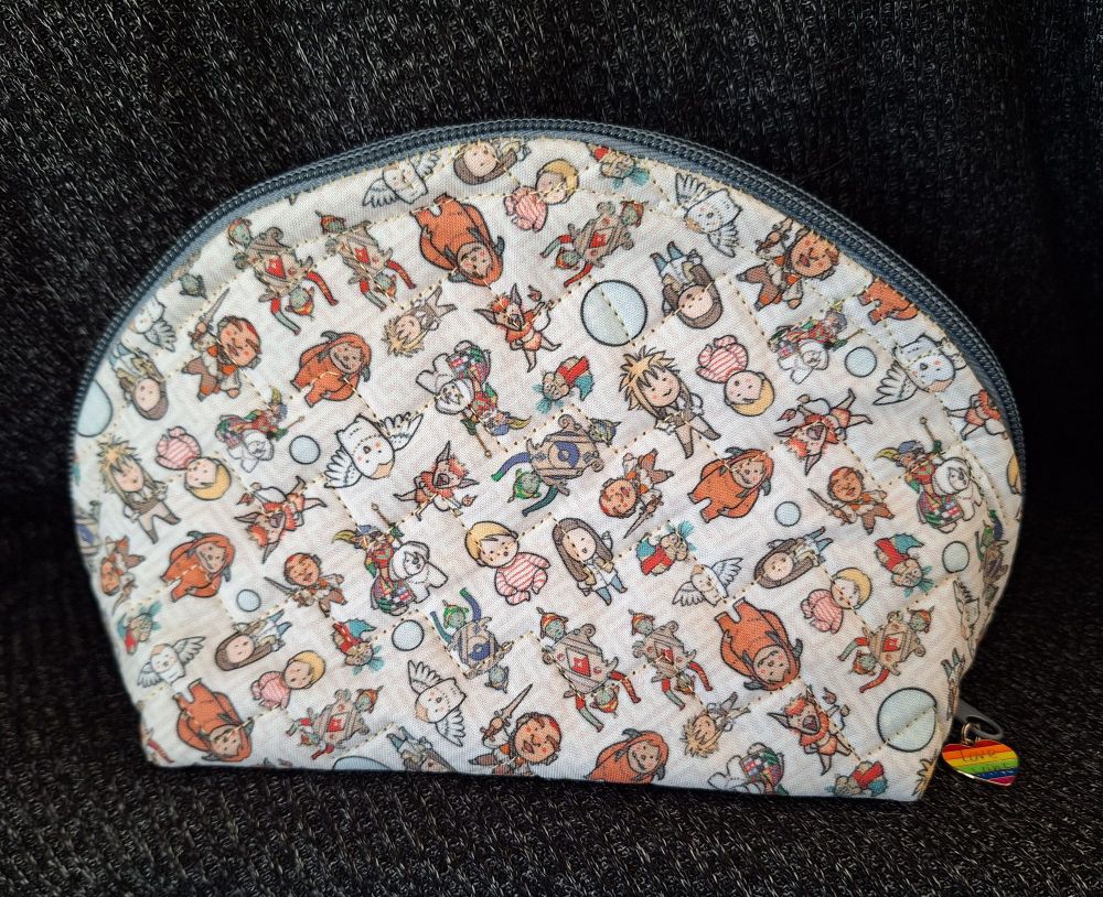 A close-up of the makeup bag, with mini-chibi Labyrinth characters, and quilted in a zig-zag pattern. There is a rainbow heart zipper pull. 