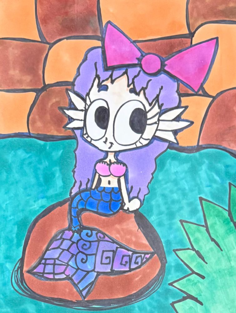 Artwork of a mermaid sitting on a rock.