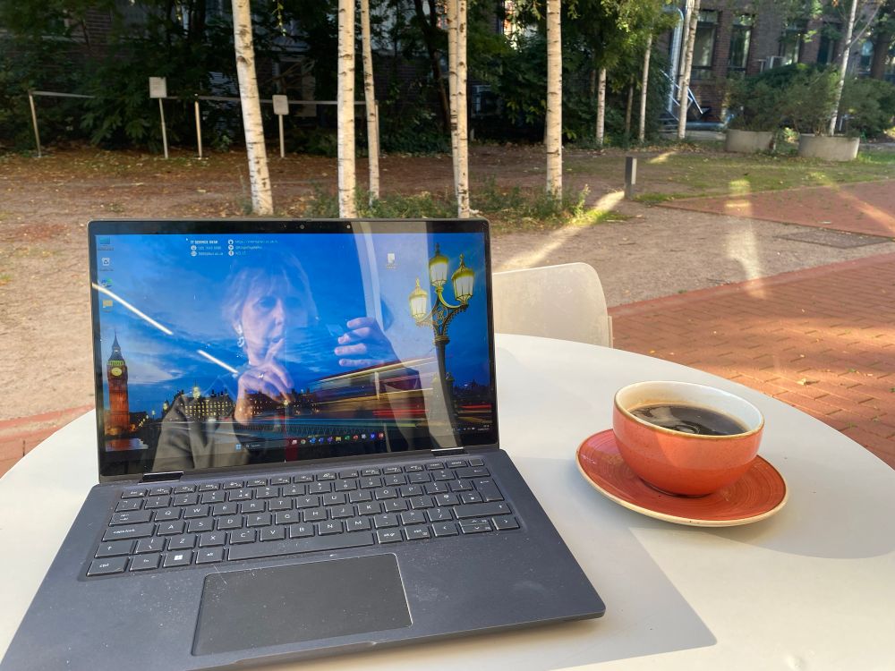 Outdoor cafe table with laptop and coffee cup 