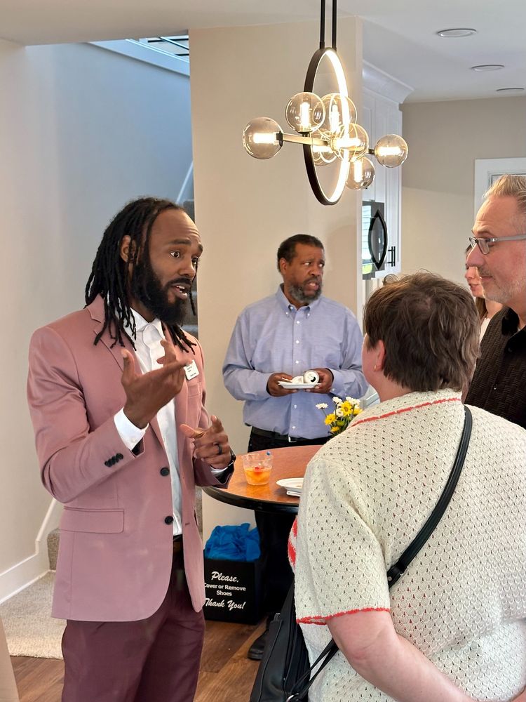 People talking in the dining room under a decorative light ficture