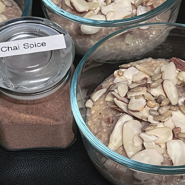 A warm bowl of chai spice oatmeal topped with almonds and sunflower seeds, exuding a cozy and inviting aroma.