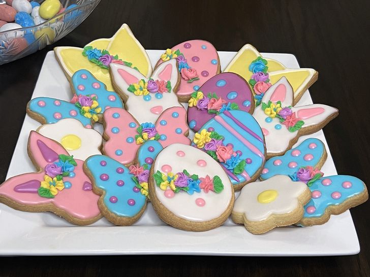 A plate of colorful decorated cookies featuring various Easter designs, including bunnies and eggs.
