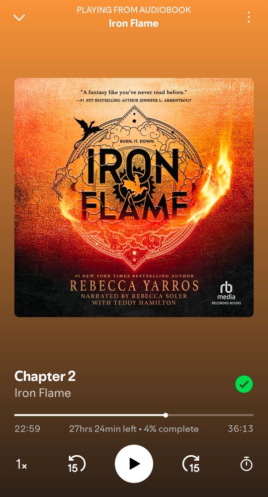 A screenshot of the audio book Iron Flame by Rebecca Yarros being played in the Spotify app. The book's cover depicts an illustration of smoke and flames with dragon silhouettes and the catch phrase "burn it down" above the book title. 