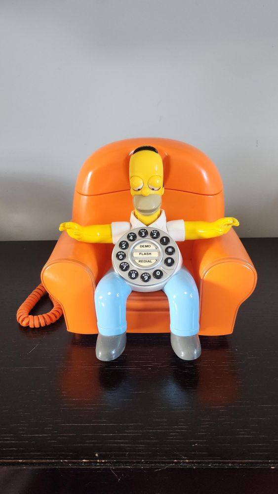 Homer Simpson sitting on a couch landline telephone.