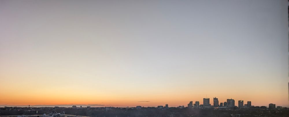 The pre-dawn sky over the skyline of Columbus, Ohio. Plenty of pink, orange, and violet appear on the horizon.