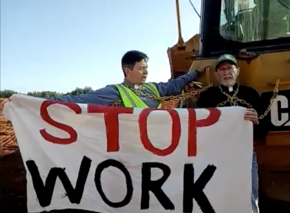 Faith leaders hold, "Stop Work" banner.