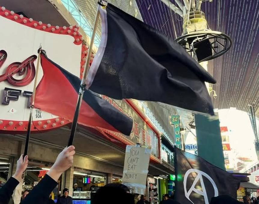 Anarchists hold up flags during protest march in Las Vegas, NV.
