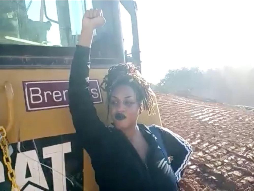 Protester blocks Cop City construction equipment.