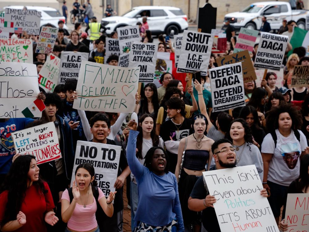 Students walkout and hold signs against ICE raids.