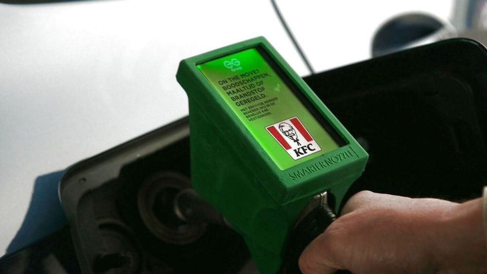 A fuel dispenser nozzle at a gas station fitted with a screen to show ads