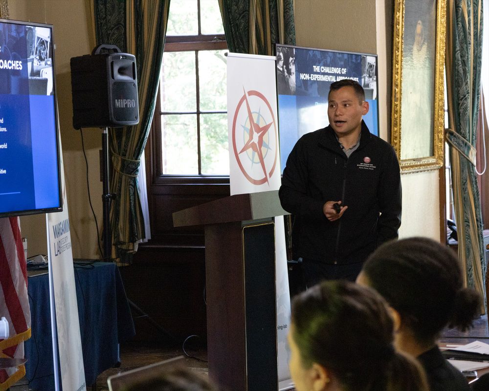Erik Lin-Greenberg lectures at the front of a room.