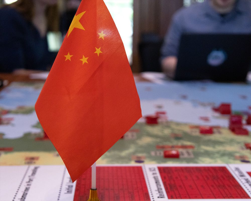 A Chinese flag in the foreground with a game board in the background.