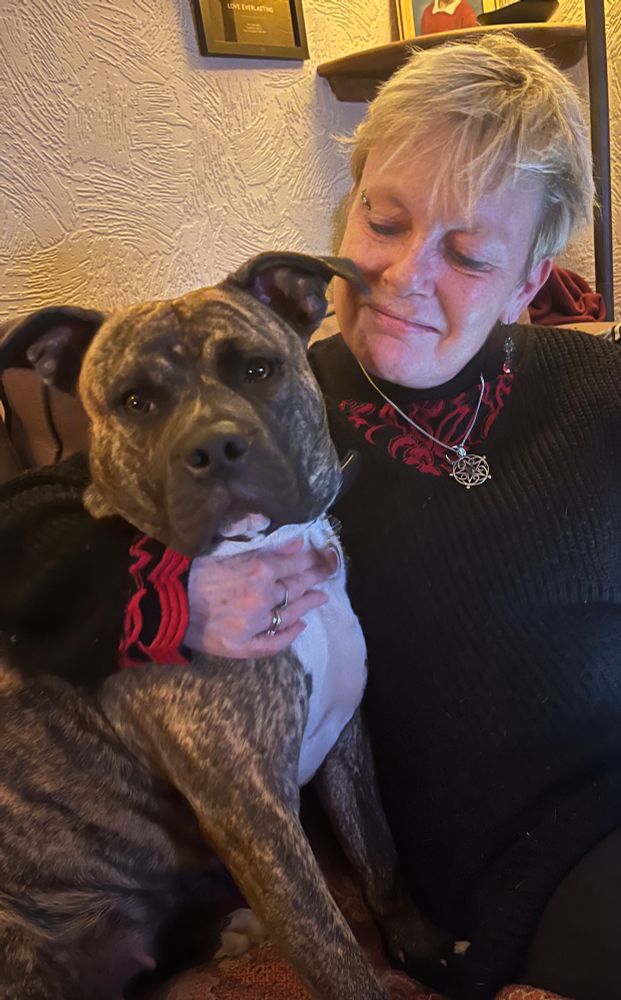 Me, with my arm around my dog Poppy, we’re both sitting on the sofa.