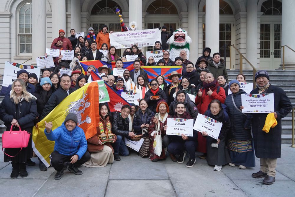 group photo on city hall steps with signs celebrating the suspension of alternate side parking on losar