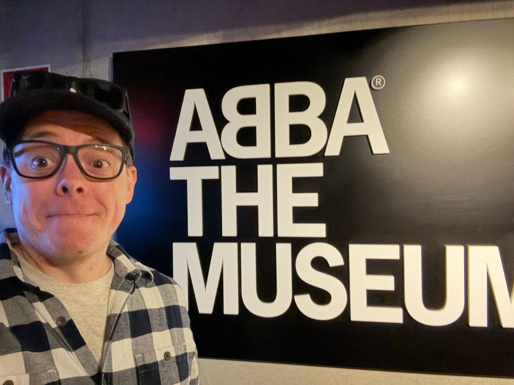 A selfie in front of a sign inside the “ABBA the Museum”. 