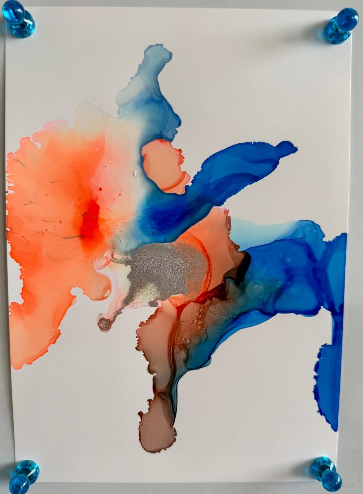 Alcohol ink artwork. A orange swirl is comining with a blue swirl. some gold is in the mix.