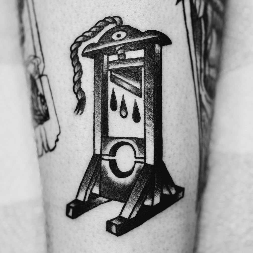 Blackwork traditional style guillotine tattoo.