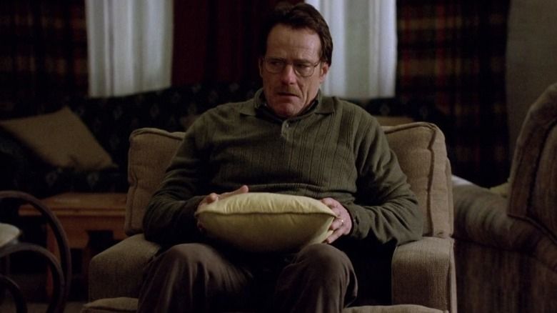 Screenshot from the show Breaking Bad of Walter sitting in his living room chair holding the "talking pillow" with an annoyed expression on his face.