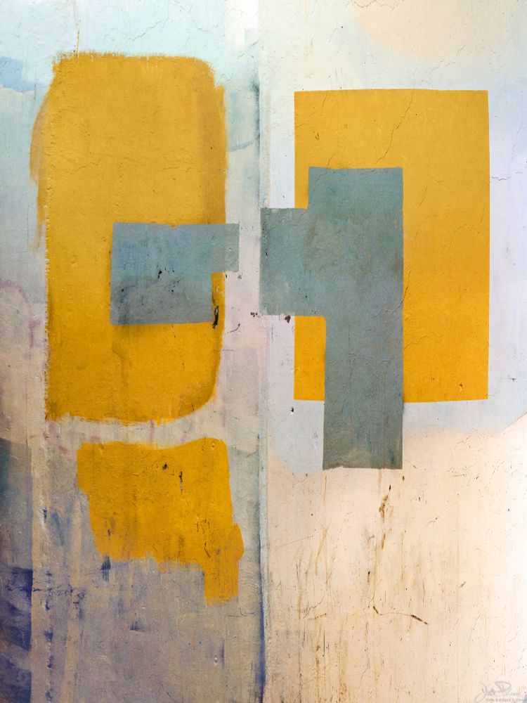 Gold paint in an alleyway covers graffiti tags. The result looks like some kind of contemporary art.