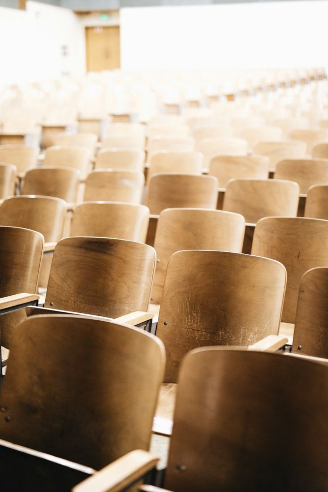 A college classroom with empty brown chairs. 