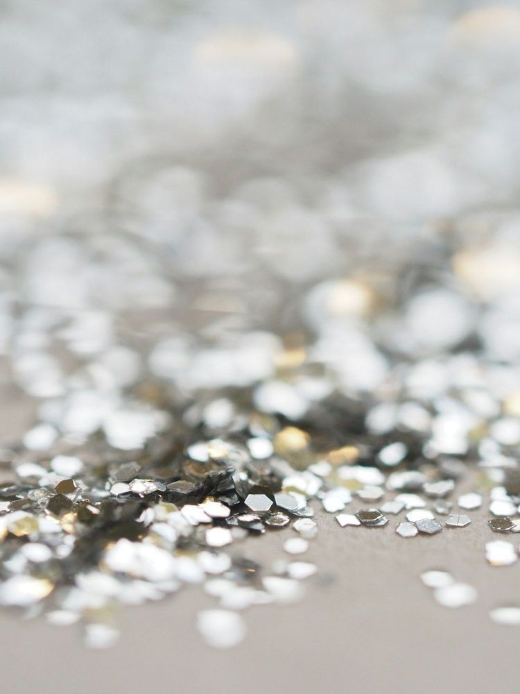 A close up of silver glitter on a silver background.